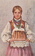 Dziewczę w stroju krakowskim niosące babę wielkanocną, której wizualnym przedłużeniem jest jego pofałdowana spódnica (1936)